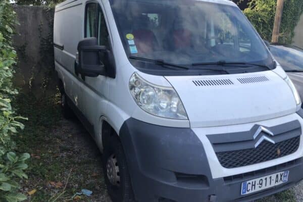 Fourgon utilitaire blanc garé dans une allée