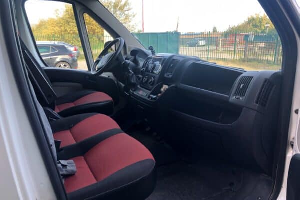 Intérieur cabine de fourgon avec sièges rouges et noirs