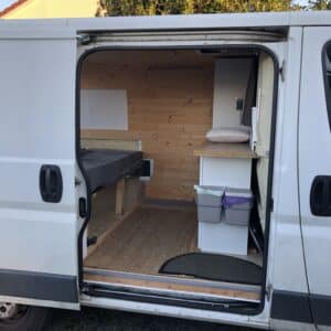 Intérieur aménagé d’un van avec lit et rangement