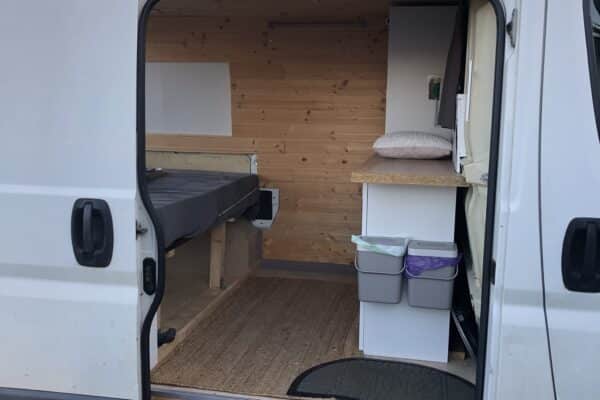 Intérieur aménagé d’un van avec lit et rangement