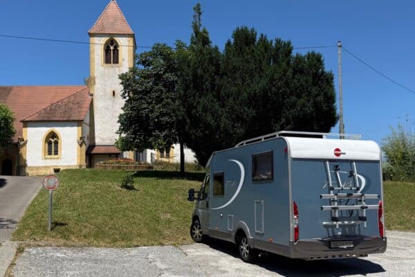 Camping-car garé près d’une église rurale