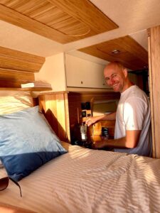 Homme prépare café dans van aménagé ensoleillé