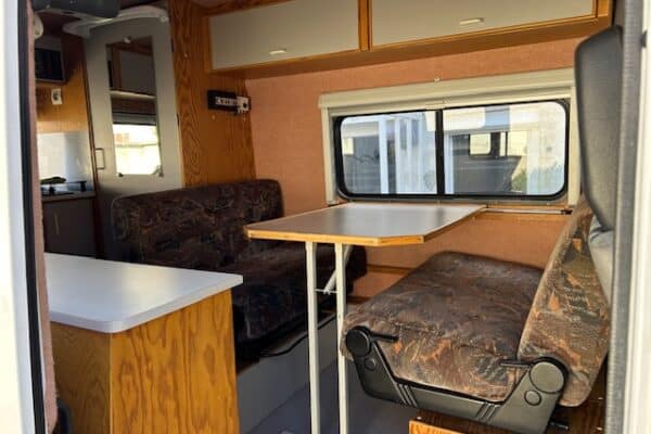Intérieur de camping-car avec coin repas et banquettes