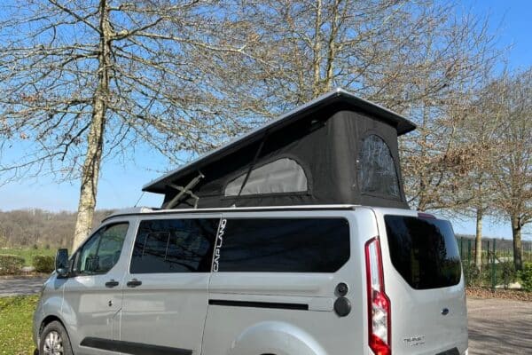 Van aménagé gris avec toit relevable ouvert