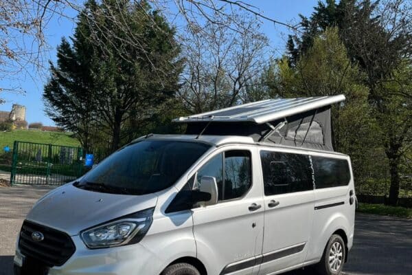 Van aménagé gris avec toit relevable ouvert