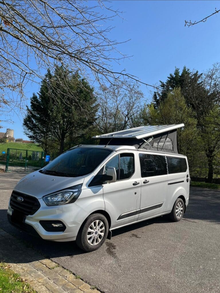 Van aménagé gris avec toit relevable ouvert