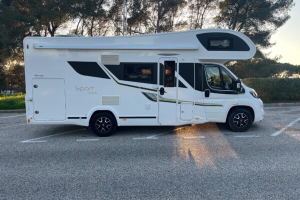 Camping-car blanc stationné au coucher du soleil