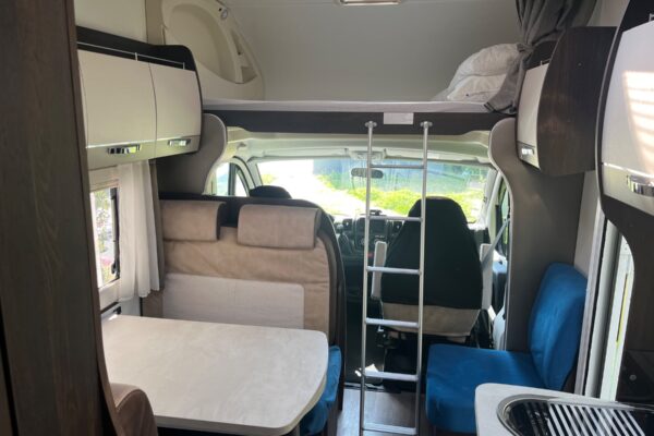Intérieur de camping-car avec lit mezzanine et dinette