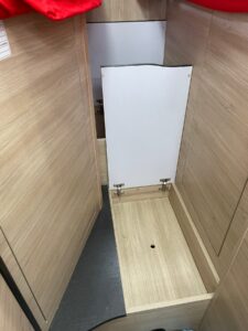 Compartiment de rangement en bois avec trappe ouverte