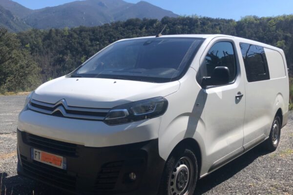 Fourgon blanc Citroën garé en montagne ensoleillée