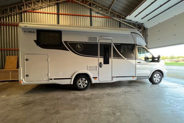 Camping-car blanc stationné dans un hangar