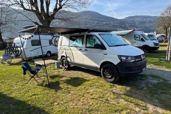 Van aménagé avec auvent dans camping montagneux