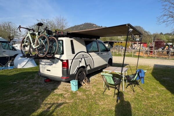 Van aménagé avec vélos et auvent en camping