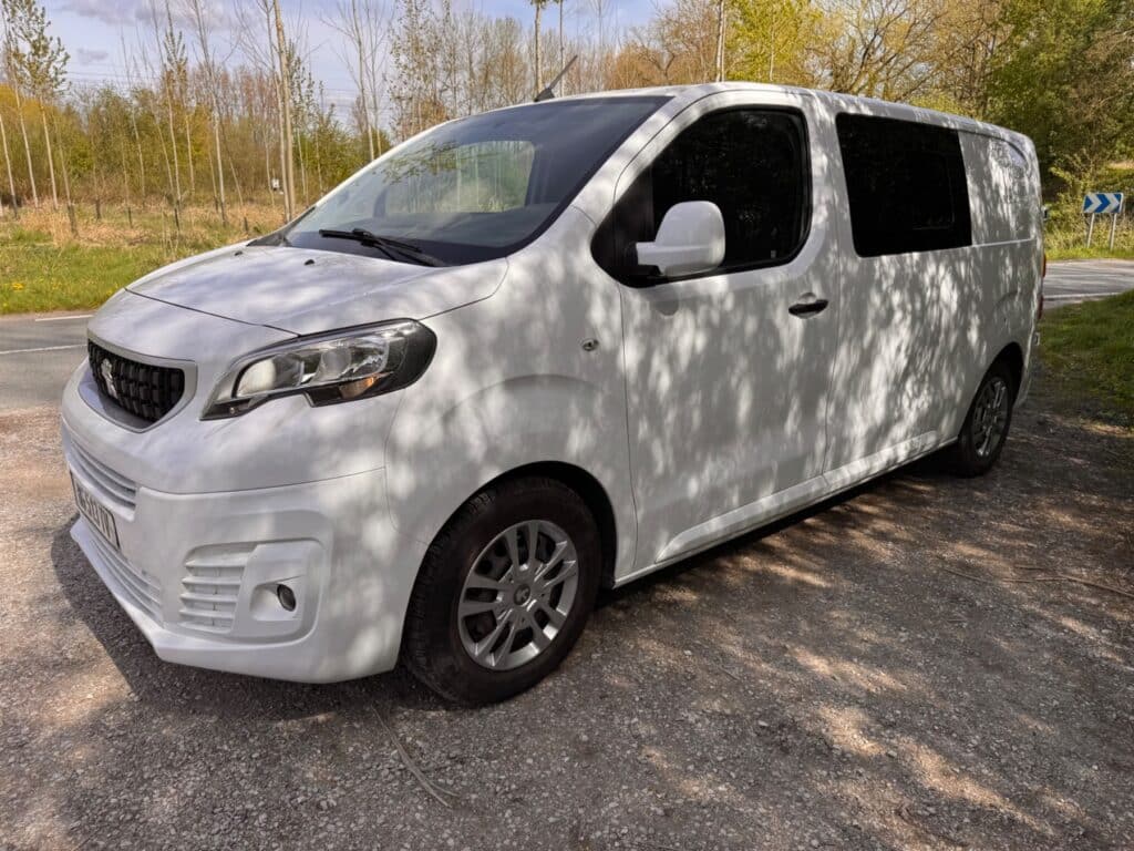 Fourgon utilitaire blanc stationné en bord de route