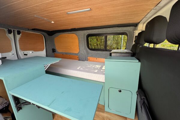 Intérieur van aménagé avec lit et table rabattable