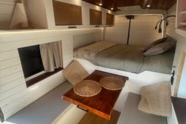 Intérieur tiny house avec lit et table escamotable