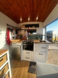 Cuisine aménagée dans un van avec plafond en bois