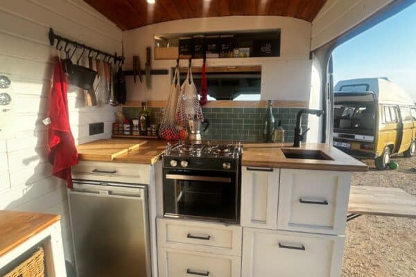 Cuisine aménagée dans un van avec plafond en bois