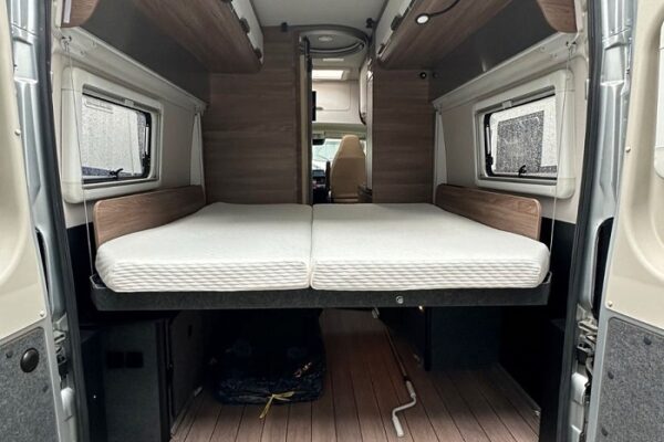 Interno camper con letto matrimoniale e finiture in legno