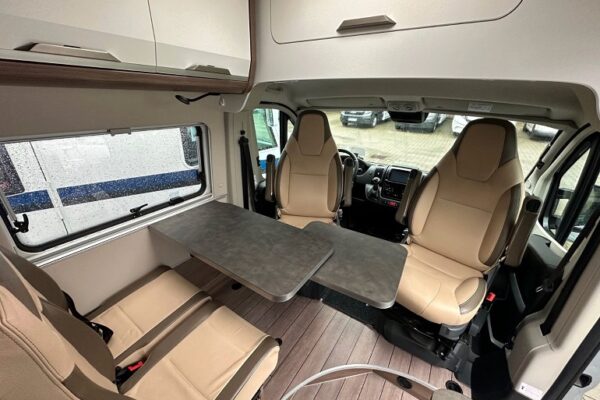 Interno camper moderno con tavolo e sedili beige