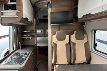 Interno moderno di camper con cucina e sedili