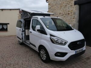 Van aménagé blanc avec toit relevable ouvert