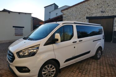 Fourgon blanc stationné dans cour pavée résidentielle