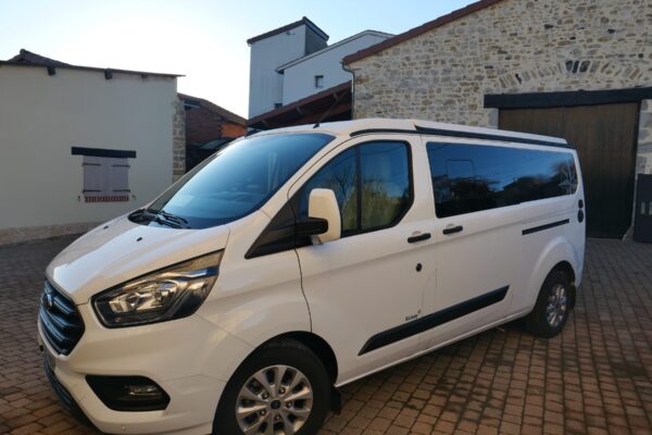 Fourgon blanc stationné dans cour pavée résidentielle