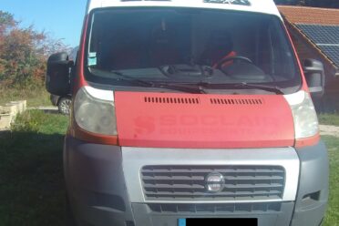 Camper Fiat rosso e bianco parcheggiato sull'erba