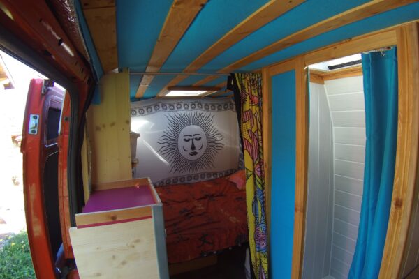 Intérieur de van aménagé avec lit et douche