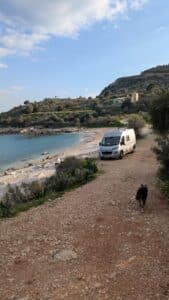 Van aménagé garé près d’une plage sauvage