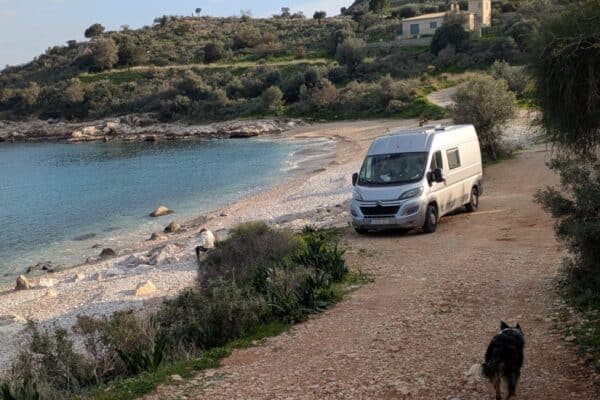 Van aménagé garé près d’une plage sauvage