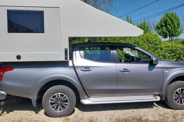 Pick-up gris avec cellule camping-car blanche