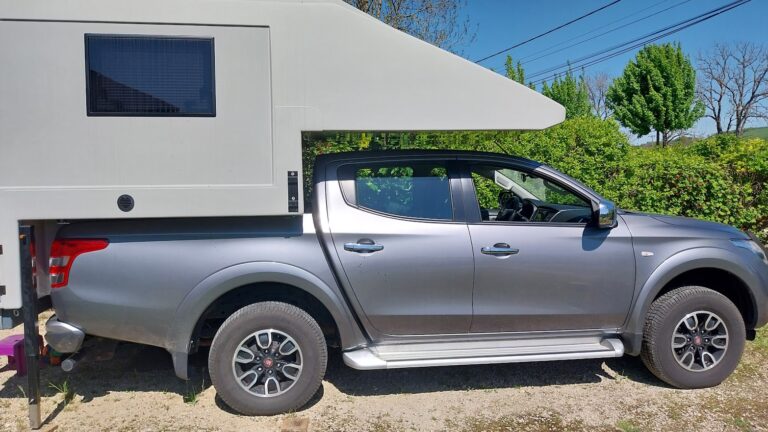 Pick-up gris avec cellule camping-car blanche
