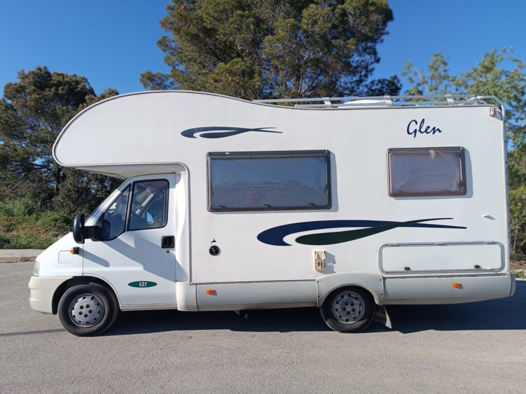 Camping-car blanc stationné au bord de route