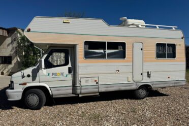 Camping-car Pilote blanc stationné sur gravier