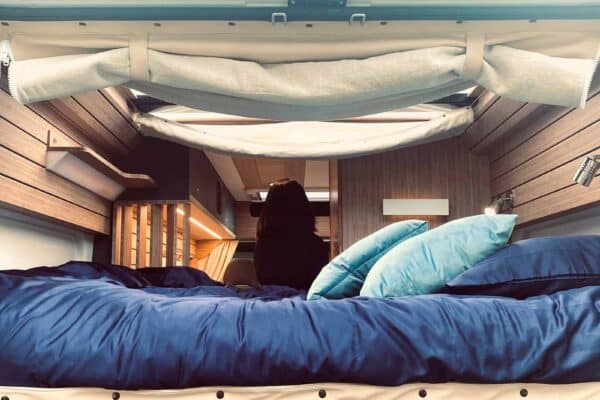 Intérieur van aménagé avec lit et voyageuse assise