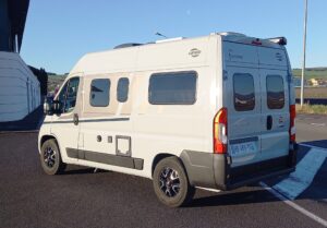Camping-car blanc stationné sur parking ensoleillé