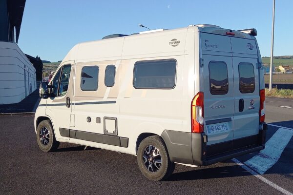 Camping-car blanc stationné sur parking ensoleillé