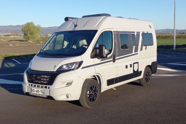 Fourgon aménagé blanc stationné en pleine campagne