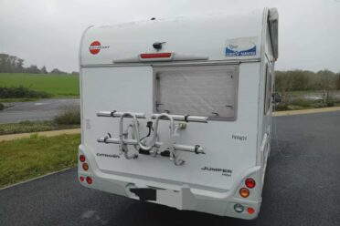 Arrière d’un camping-car blanc avec porte-vélos