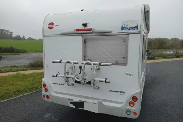 Arrière d’un camping-car blanc avec porte-vélos