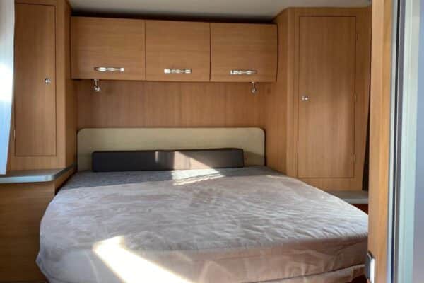 Chambre de camping-car avec lit rond et rangements