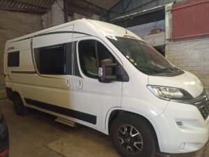 Fourgon aménagé blanc stationné dans un garage
