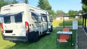 Camping-car blanc stationné avec table extérieure