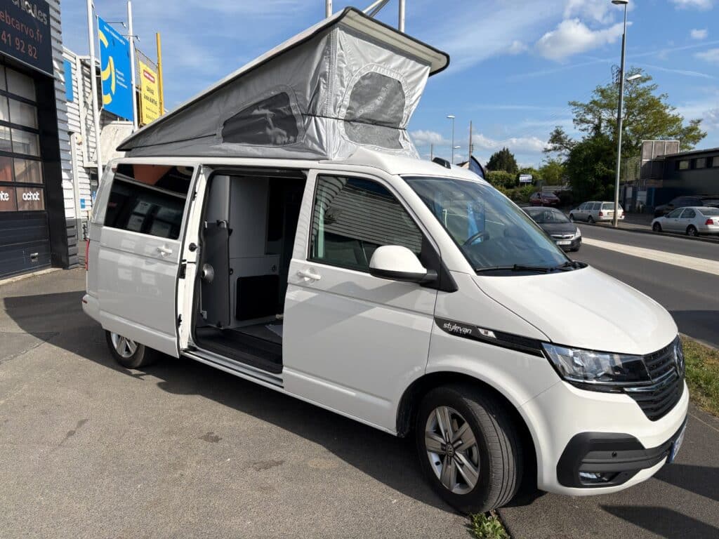 Van aménagé blanc avec toit relevable ouvert