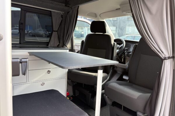 Intérieur de van aménagé avec table et sièges pivotants
