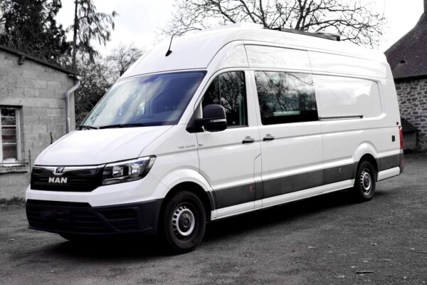 Fourgon utilitaire blanc MAN stationné en extérieur