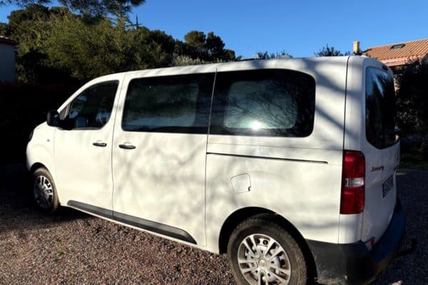 Fourgon blanc stationné sur une allée en gravier