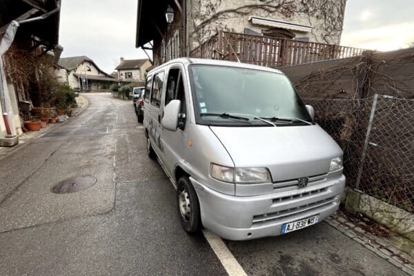 Fourgon argenté stationné dans rue de village